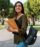 woman holding laptop and backpack